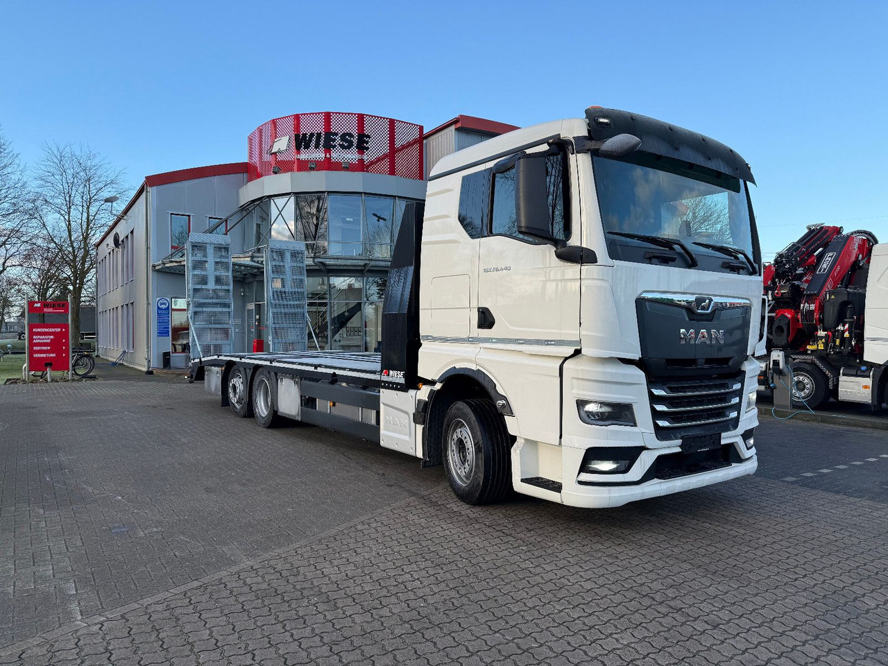 MAN Baumaschinen- Arbeitsbühnentransporter Rampen - Camião de caixa aberta/ Plataforma: foto 1 MAN Baumaschinen- Arbeitsbühnentransporter Rampen - Camião de caixa aberta/ Plataforma: foto 1