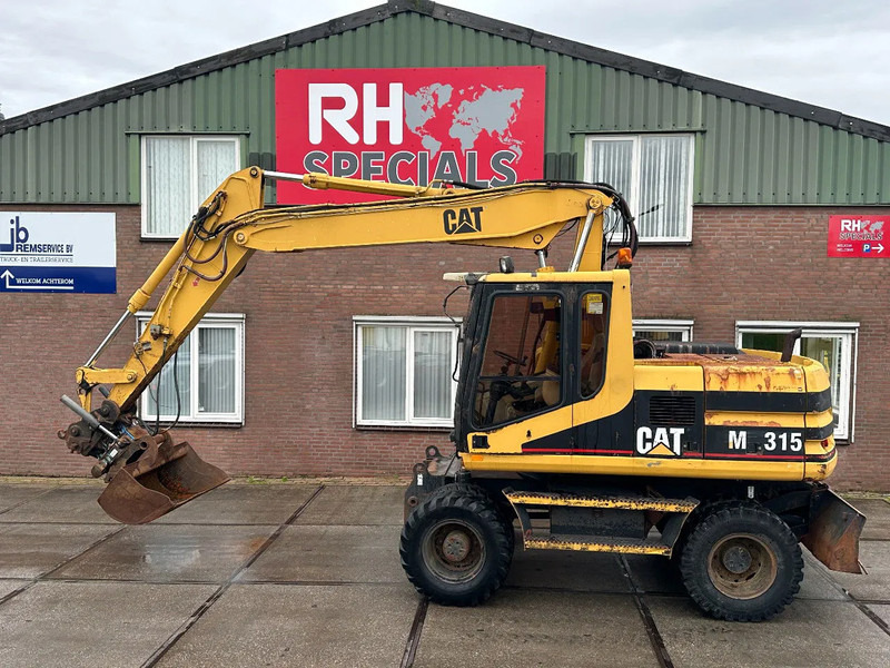Caterpillar M315 +ROTO CE - Escavadeira de rodas: foto 1 Caterpillar M315 +ROTO CE - Escavadeira de rodas: foto 1